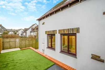 a white house with a green lawn in the backyard at 2 Bed in Padstow oc-t30497 in Padstow