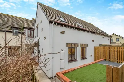 a white house with a green lawn in front of it at 2 Bed in Padstow oc-t30497 in Padstow