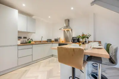 a kitchen with white cabinets and a wooden table at 2 Bed in Padstow oc-t30497 in Padstow