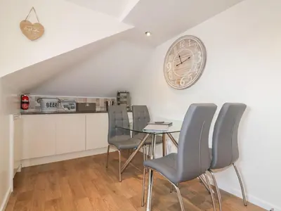 a dining room with a table and chairs and a clock at Atlantic View in Newquay