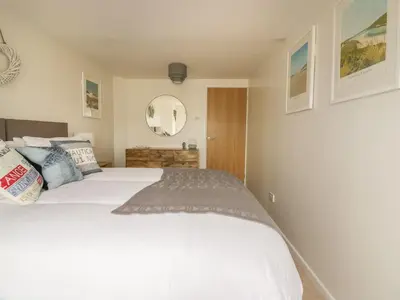 a bedroom with a white bed and a mirror at Atlantic View in Newquay