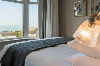 a bedroom with a bed and a large window at The Gannet Inn in St Ives