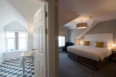 a bedroom with a bed and a desk and a chair at The Gannet Inn in St Ives