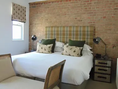 a bedroom with a large white bed with a brick wall at The Gannet Inn in St Ives