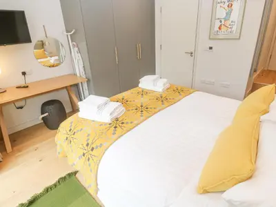 a bedroom with a large bed with towels on it at Villa 80 in St Ives