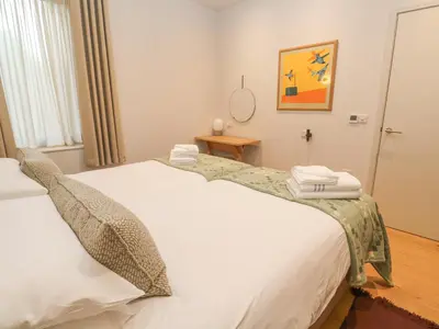 a bedroom with a white bed with towels on it at Villa 80 in St Ives