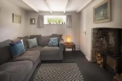 a living room with a couch and a fireplace at Gorgeous Cottage Parking Short Walk to Beach in Gorran Haven