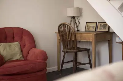 a chair sitting next to a desk with a lamp at Gorgeous Cottage Parking Short Walk to Beach in Gorran Haven