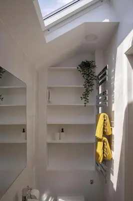 a bathroom with a sink and a skylight at Stylish Boatshed with Sea Views Private Parking in Gorran Haven