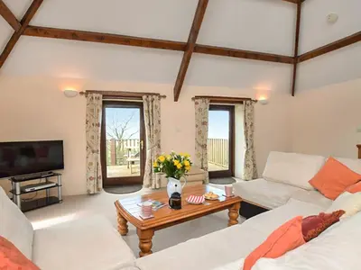 a living room with two couches and a coffee table at Miller's Cottage -Uk48595 in Warbstow