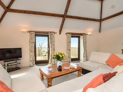 a living room with two white couches and a table at Miller's Cottage -Uk48595 in Warbstow