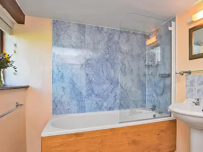 a bathroom with a tub and a sink at Miller's Cottage -Uk48595 in Warbstow