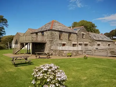 a large stone house with a picnic table in a yard at Miller's Cottage -Uk48595 in Warbstow