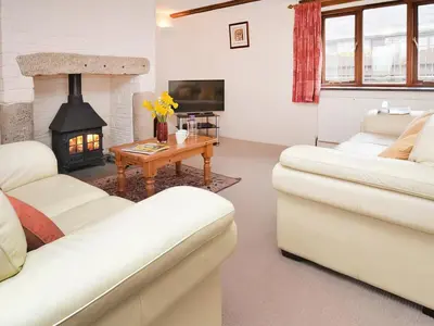 a living room with two white couches and a fireplace at Bill And Ben's Cottage - Uk48619 in Warbstow