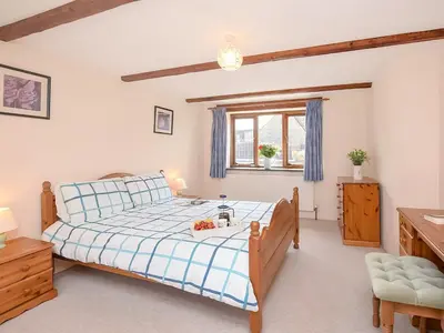 a bedroom with a bed with a blue and white comforter at Bill And Ben's Cottage - Uk48619 in Warbstow