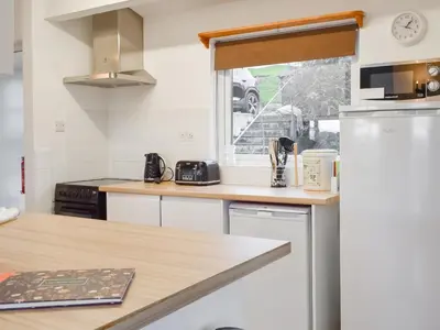 a kitchen with a counter top and a refrigerator at Pencarrow in Fowey