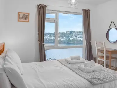 a bedroom with a bed and a large window at Pencarrow in Fowey