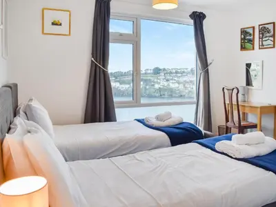 two beds in a room with a window at Pencarrow in Fowey