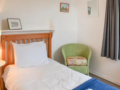 a bedroom with a bed and a chair at Pencarrow in Fowey