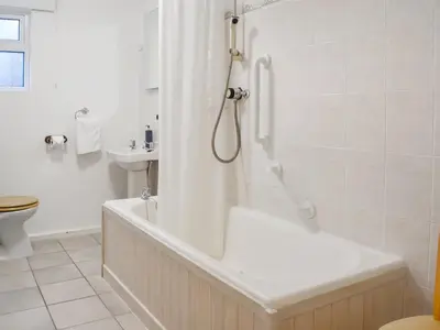 a bathroom with a shower and a tub and a sink at Pencarrow in Fowey