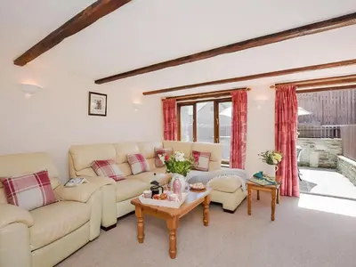 a living room with couches and a table at Grandma's Cottage - Uk48618 in Warbstow