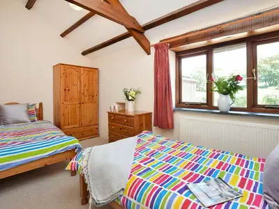 a bedroom with two beds and a window at Grandma's Cottage - Uk48618 in Warbstow