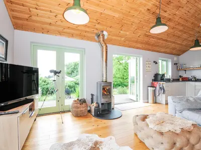 a living room with a wood burning stove in it at Smugglers in Bodmin
