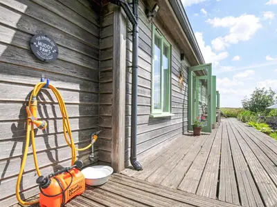 a yellow hose is on the side of a house at Smugglers in Bodmin