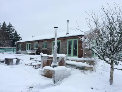 a house covered in snow in front of a house at Smugglers in Bodmin