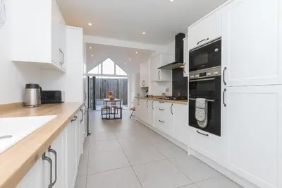 a kitchen with white cabinets and a counter top at Captain's Walk in Newquay