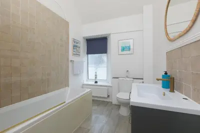 a bathroom with a tub and a toilet and a sink at Captain's Walk in Newquay