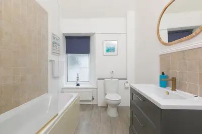 a bathroom with a tub and a toilet and a sink at Captain's Walk in Newquay