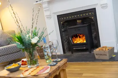 a living room with a fireplace and a coffee table with a fire place at Captain's Walk in Newquay