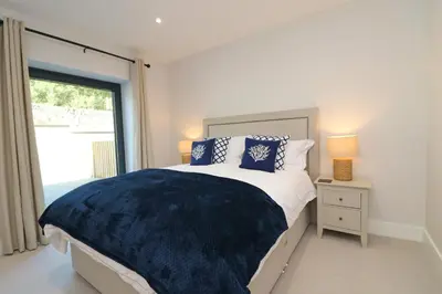 a bedroom with a large bed and a window at Fifty Steps from the beach! in St Merryn