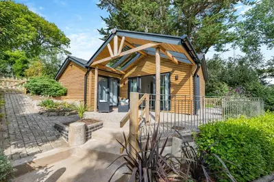 a small wooden cabin with a black roof at 1 Bed in Tresillian oc-p30116 in Saint Clement