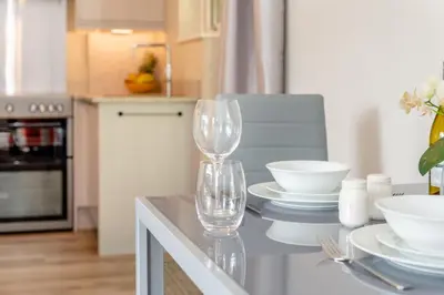 a kitchen with two wine glasses on a table at 1 Bed in Tresillian oc-p30116 in Saint Clement