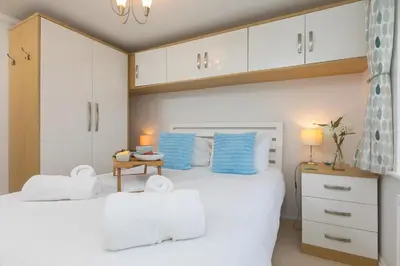 a bedroom with two white beds and a table at Ocean View in Carbis Bay
