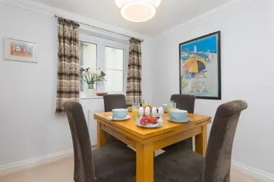 a dining room with a wooden table and chairs at Ocean View in Carbis Bay