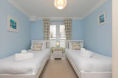 two beds in a room with blue walls at Ocean View in Carbis Bay