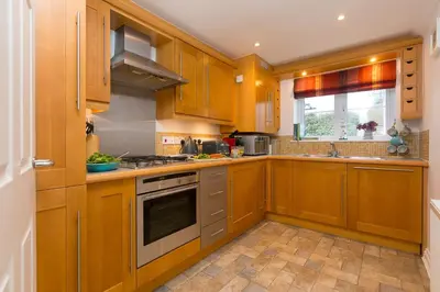 a kitchen with wooden cabinets and a stove top oven at Ocean View in Carbis Bay