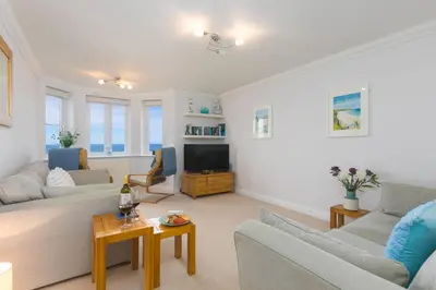a living room with two couches and a tv at Ocean View in Carbis Bay