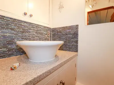 a bathroom with a white sink on a counter at Rose Cottage in Falmouth