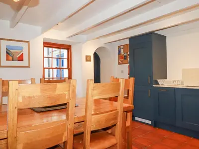 a dining room with a wooden table and chairs at Rose Cottage in Falmouth