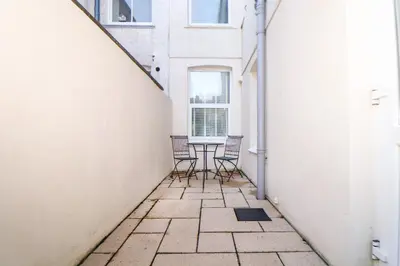 a balcony with chairs and a table in a building at 5 Fistral Waves in Newquay