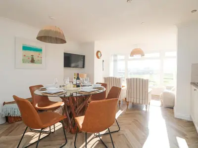 a dining room with a table and chairs at 5 Fistral Waves in Newquay