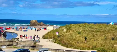 a group of people on a beach near the ocean at 15 Penhale, Perranporth in Perranporth