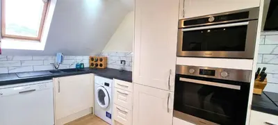 a kitchen with a microwave oven and a dishwasher at 15 Penhale, Perranporth in Perranporth