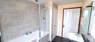 a bathroom with a shower and a tub and a sink at 15 Penhale, Perranporth in Perranporth