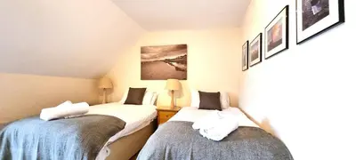 a room with two beds with towels on them at 15 Penhale, Perranporth in Perranporth