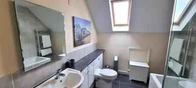 a bathroom with a sink and a toilet and a mirror at 15 Penhale, Perranporth in Perranporth